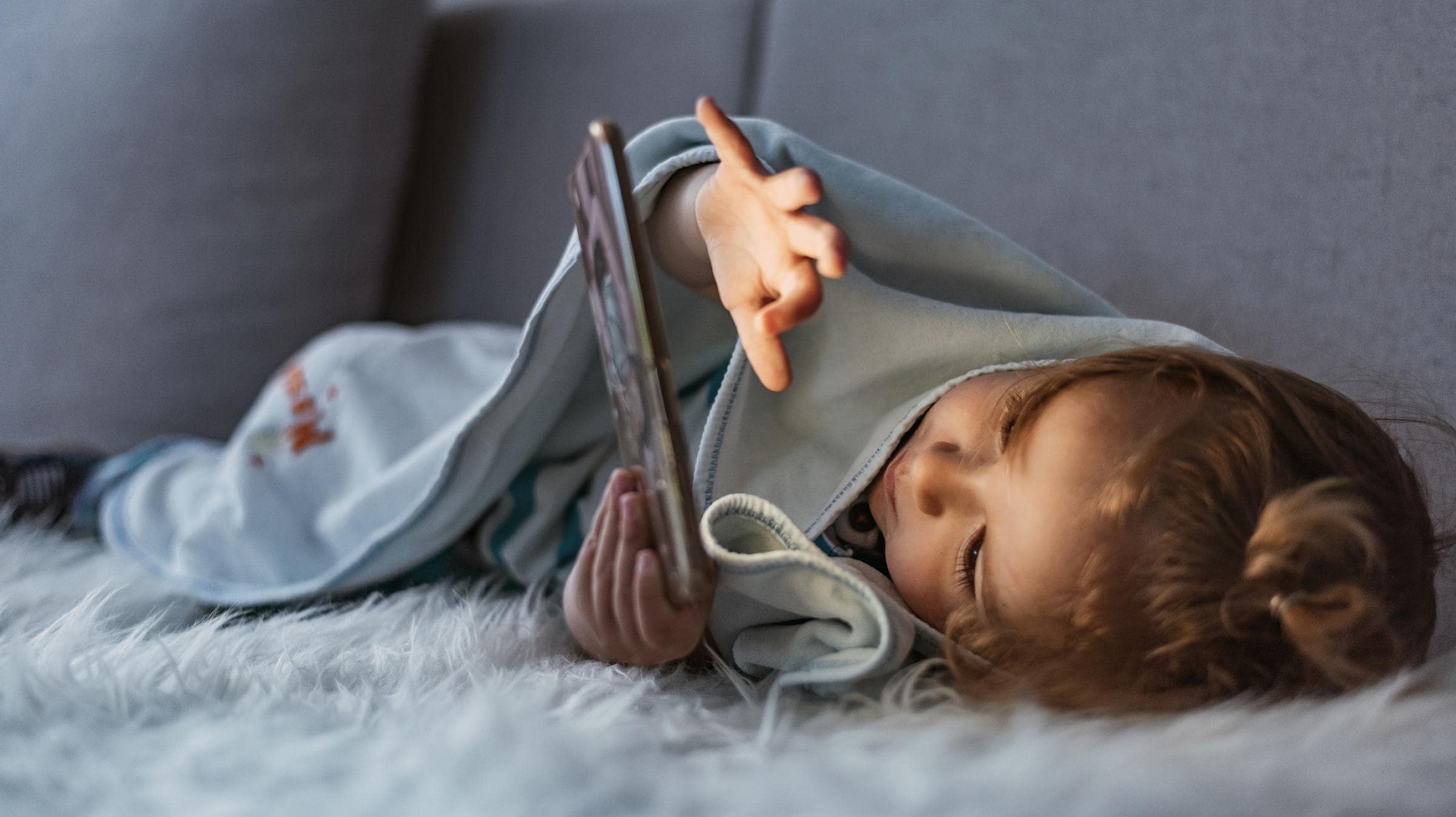 کودک بی حال در حال کار با گوشی